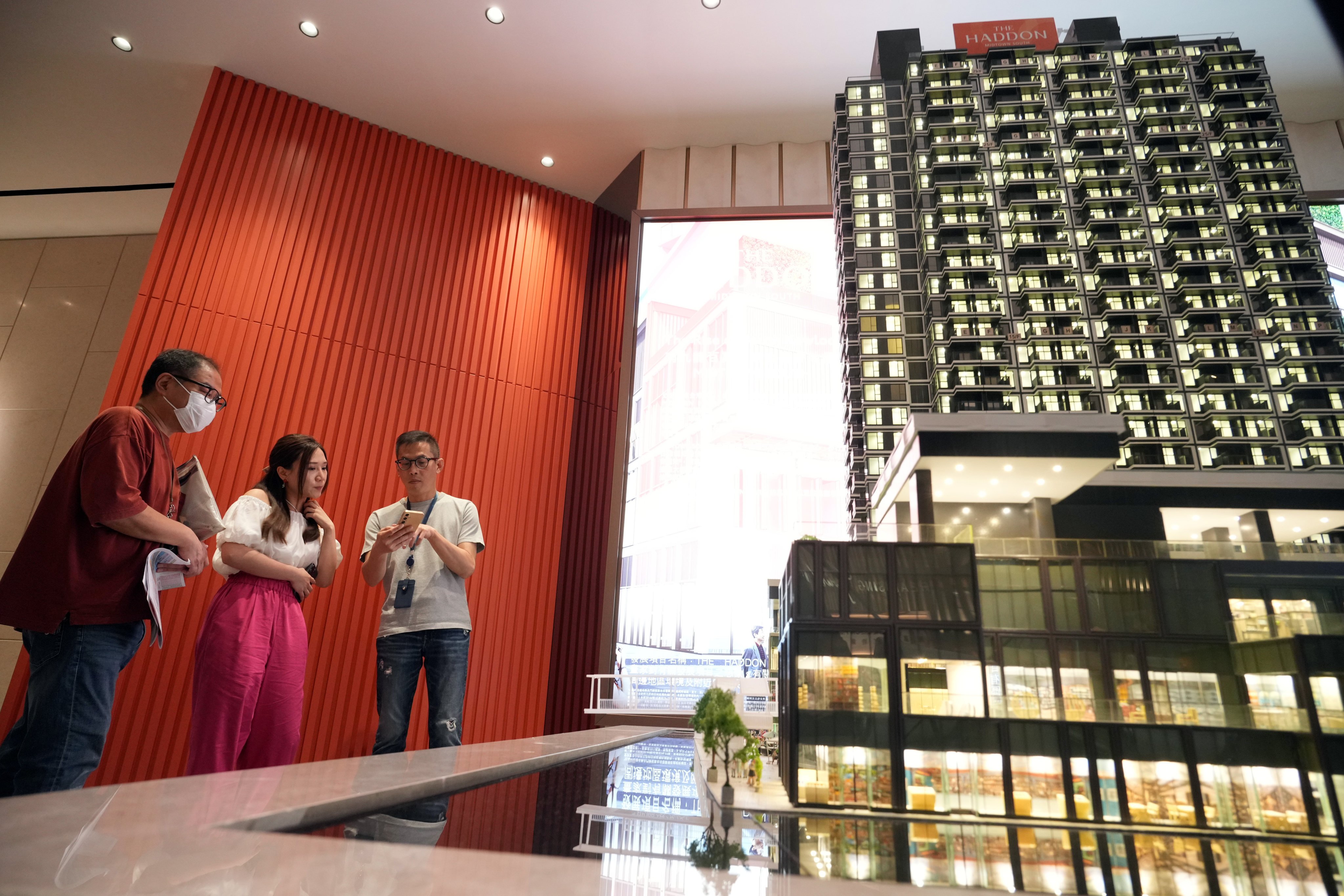 Potential buyers look at a model residential project by Henderson Land in a showroom in Tsim Sha Tsui in June 2024. May Tse